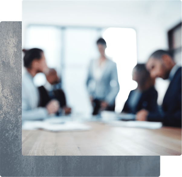 A group of people in business suits sitting around a conference table.