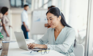 Woman working on a laptop in an office.